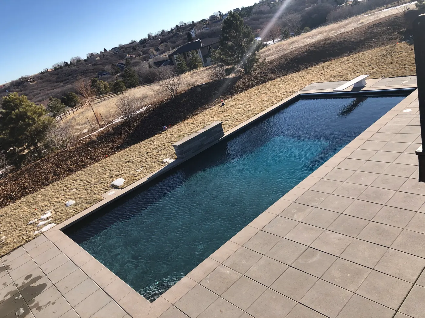 Dark lap pool set into a stone terrace with the foothills beyond