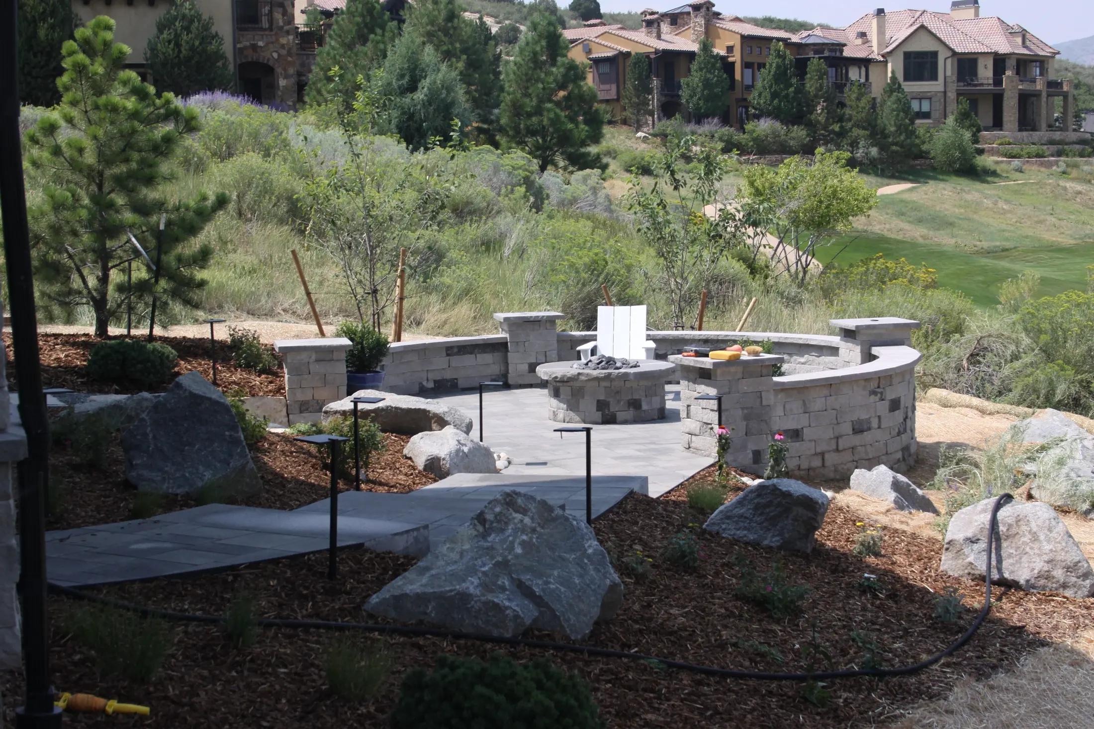 Stone fire terrace with seat walls set into a hillside