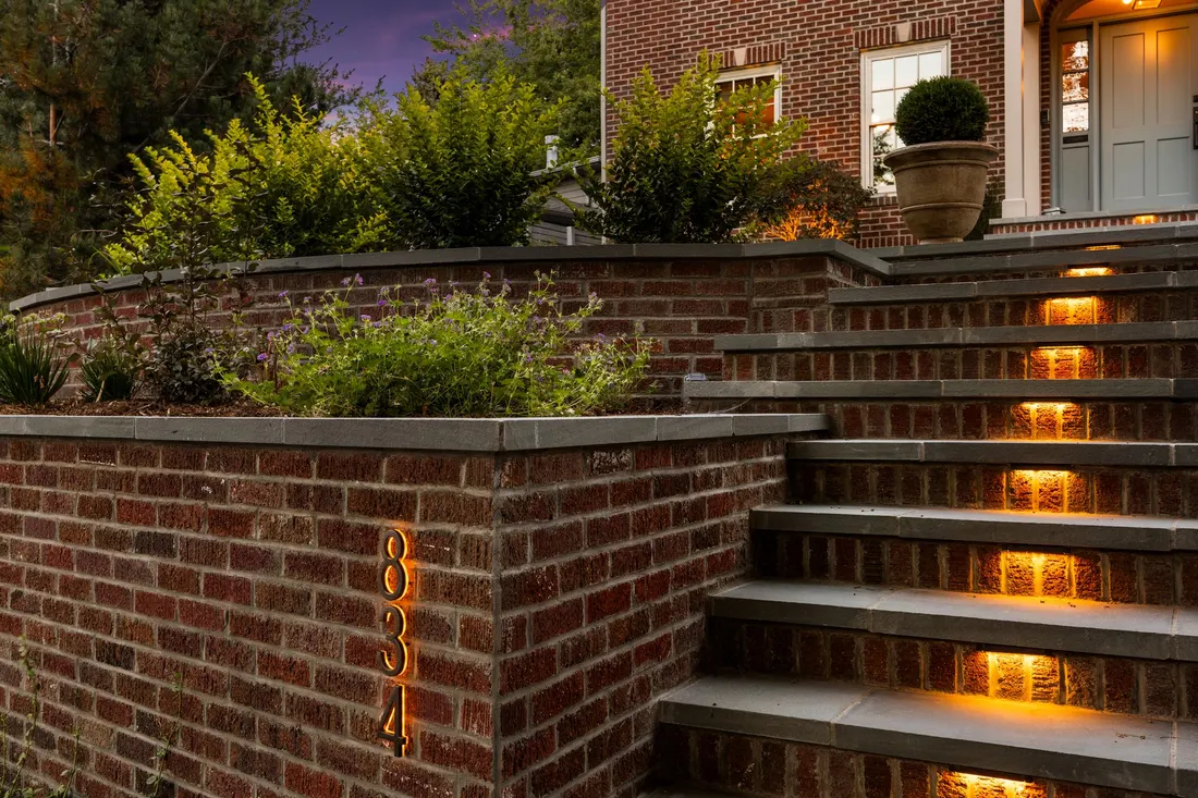 Brick retaining wall with illuminated bluestone stair treads