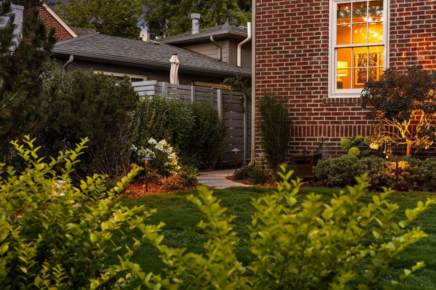 Layered shrub planting against a brick facade