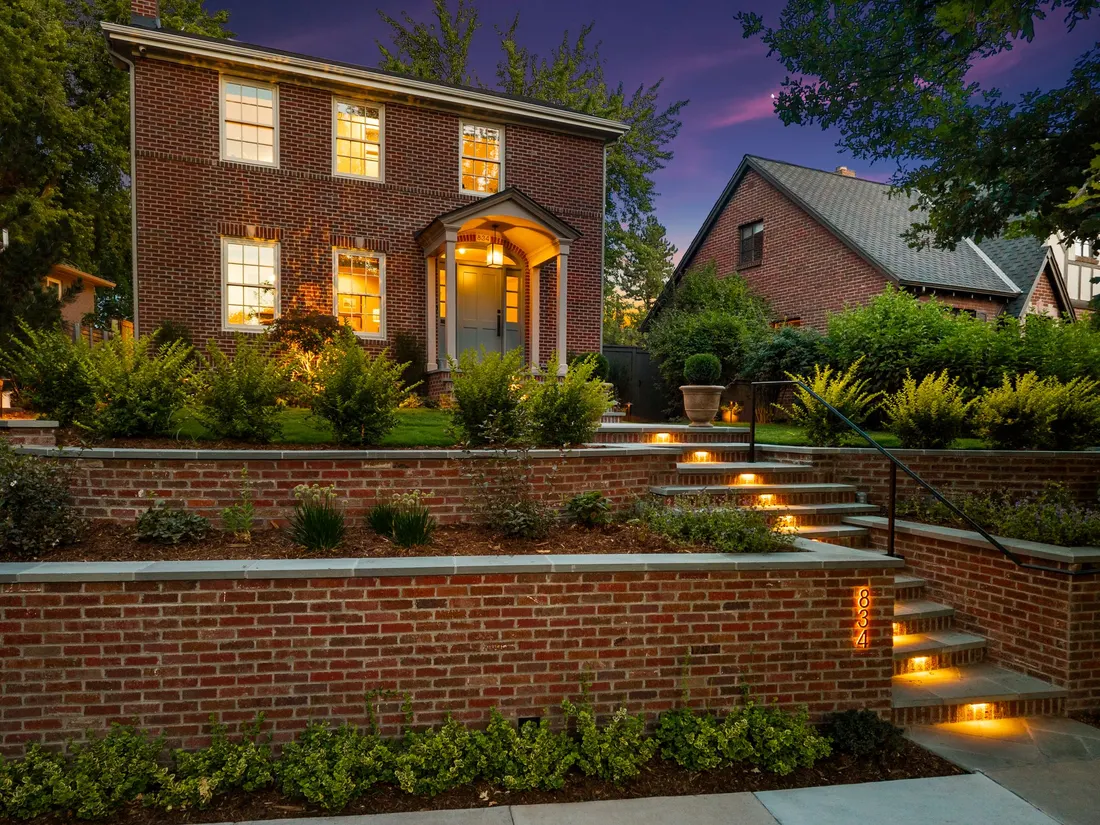 Tiered brick retaining walls with lit bluestone stair treads